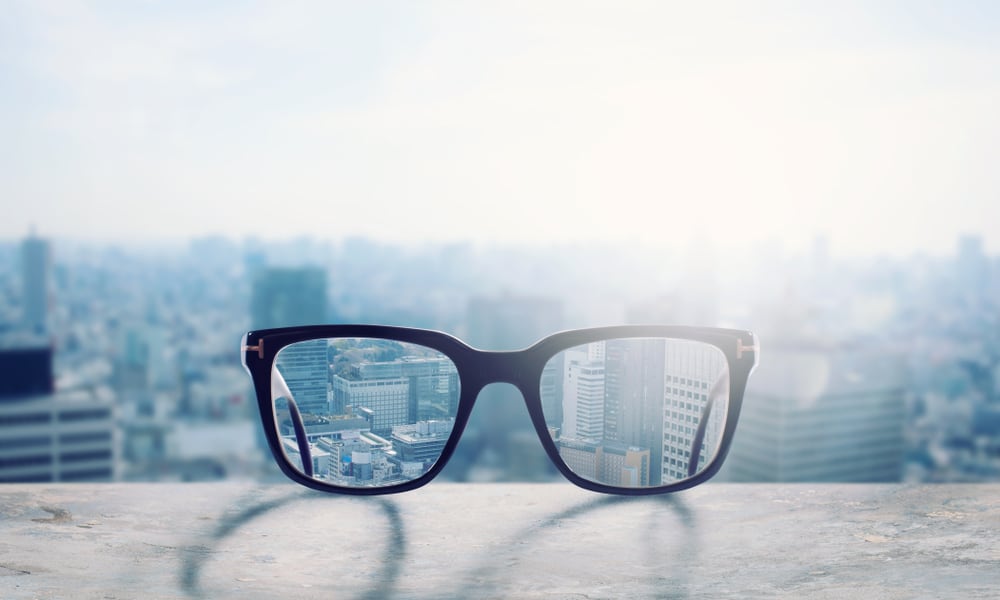 Vision Correction - Glasses Correcting eyeglasses on a ledge of a skyscraper overlooking the city